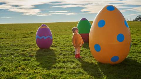 child with giant easter eggs