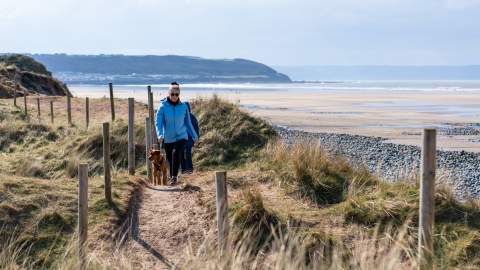 dog walkers at Westward Ho beach, spring, autumn