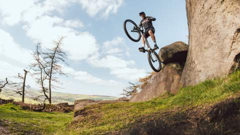 BMX rider doing a flip off a rock
