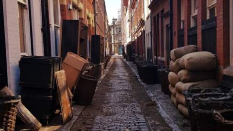 Old town in Hull decorated with movie props such as sacks of flour and baskets.