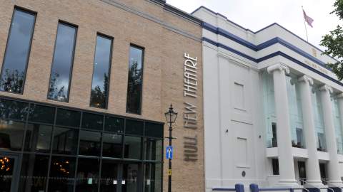 Exterior view of Hull New Theatre showing its modern glass extension and grand white columned façade in the city centre of Hull.