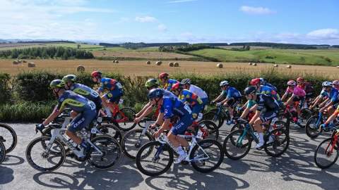 Tour of britain peloton rides past rolling hills and fields