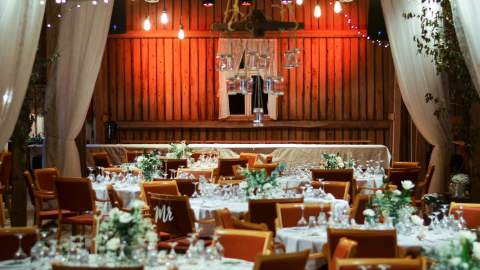 Låven på Geiteberg er dekket til fest med masse bord med hvite duker