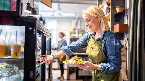 En ung dame tar ut en salatbolle fra disken