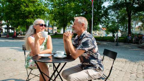 Par drikker kaffe på en fortauskafé i Halden