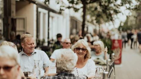 Glade mennesker på en uteservering i gågata i Sarpsborg. Foto
