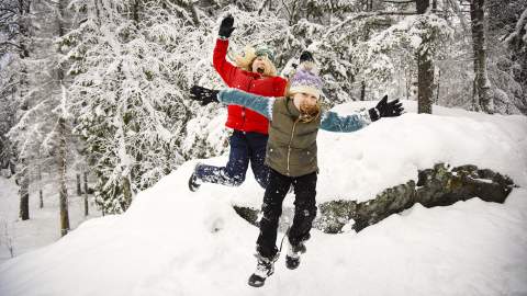 To jenter som leker i snøen i Mossemarka