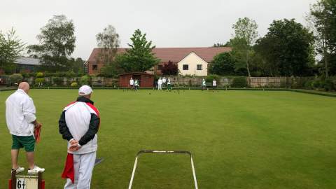 Lawn bowling players waiting on green grass for match to start