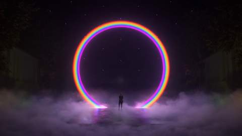 Image shows Lightport installation a large scale rainbow archway with a person standing underneath the centre of the archway