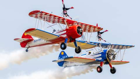 Image shows two Aerosuperbatics Wingwalkers aircraft in flight