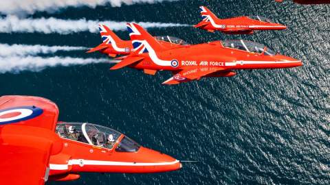 5 Red Arrows flying above open water