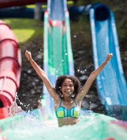Woman exits water slide with splashing water