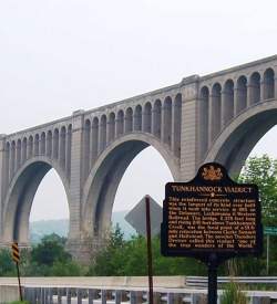 A large bridge over a road with a plaque