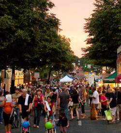 People walking and wandering around a Main Street at dusk