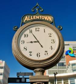 A large historic clock in a city center that reads Allentown