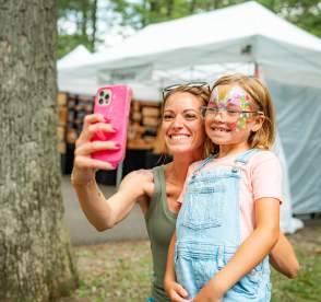 Mother taking a photo with her daughter at a festival