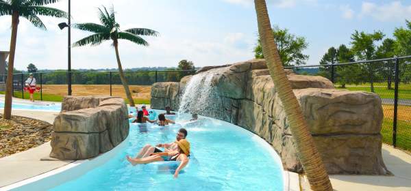 Children and adults float down a cool, blue lazy river at Parrot Island Water Park in Fort Smith.