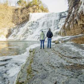 two people viewing Ithaca Falls in late winter