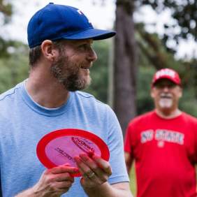 Two men playing disc golf in a park in Nash County, North Carolina