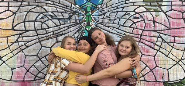 Teens posing in front of Dragonfly wall mural in Beaumont