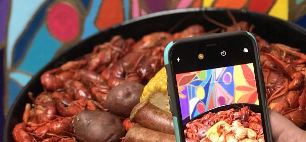 Phone taking a picture of a Beaumont crawfish dish