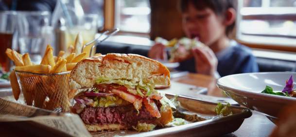 Cheeseburger and fries on a restaurant table.