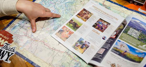 Person observing a map, pointing towards locations.