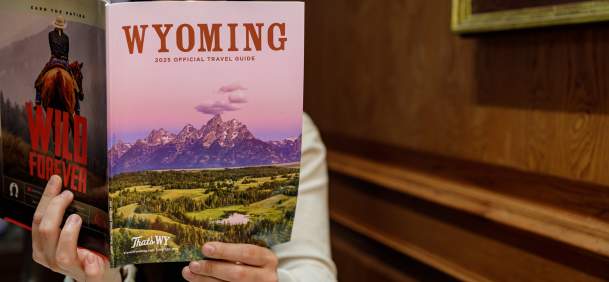 Person holding and reading the official printed Travel Guide
