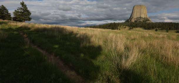 A massive geologic marvel under the endless summer sky of Crook County, Wyoming. Sun-drenched and imposing.