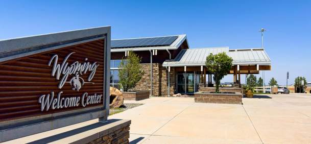 A Wyoming welcome center with a sign out front.