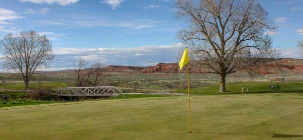 Lush green fairway at the Thermopolis Golf Course with rolling hills in Hot Springs County, Wyoming.