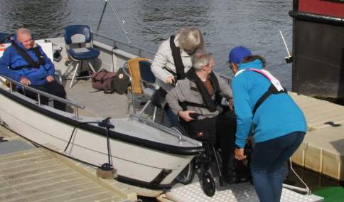 A wheelchair being loaded onto a boat