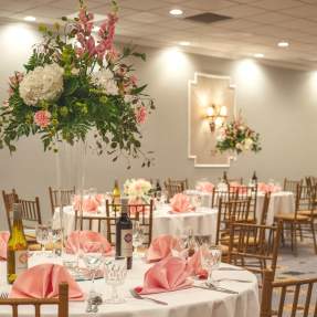 Ballroom set up with pink and white decor and flower center pieces at the MCM Elegante Beaumont