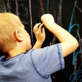 Kid Drawing On The Crown Pizza Chalk Wall In Beaumont, TX