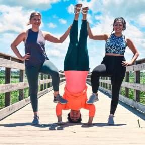 Women in yoga attire posing on the Cattail Marsh Boardwalk In Beaumont, TX