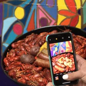 Phone taking a picture of a Beaumont crawfish dish