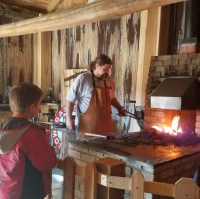 A father and son enjoy the blacksmith demonstration at Waverly Park.