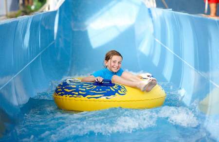 Girl in an inflatable ring on a water slide.