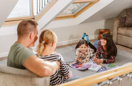 A family of a man, woman and two girls in an apartment.