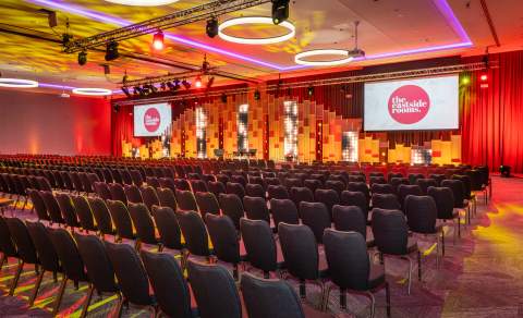 Eastside Rooms Affinity Suite, theatre style chair layout with two screens and vibrant lighting