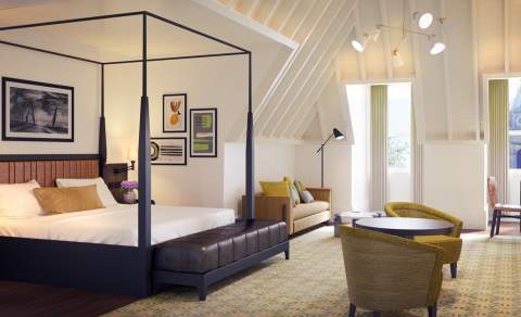 The Grand Hotel luxury suite, featuring a canopy bed, table and two chairs