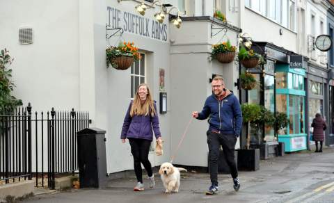 People walking a dog through The Suffolks in Cheltenham.