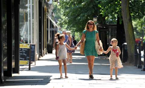 A family walking down The Promenade in Cheltenham.