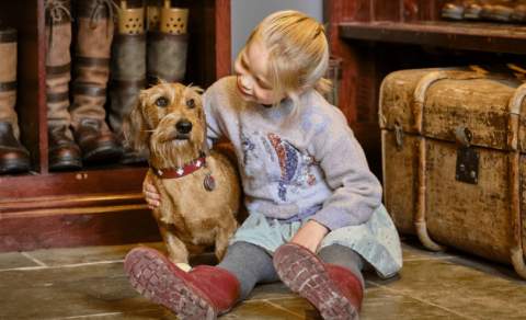 A girl sat with a dog at Ellenborough Park Hotel in Cheltenham