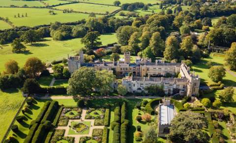 Aerial view of Sudeley Castle amongst rolling hills