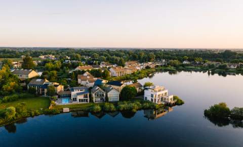 Aerial view of Lower Mill Estate with lake in the foreground and holiday accommodation behind