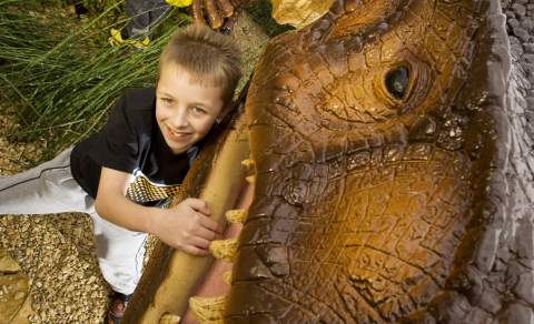 Child next to a dinosaur
