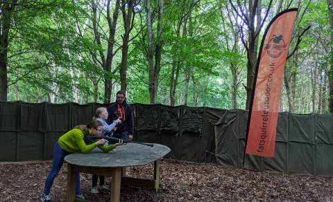 Children shooting guns in the woods