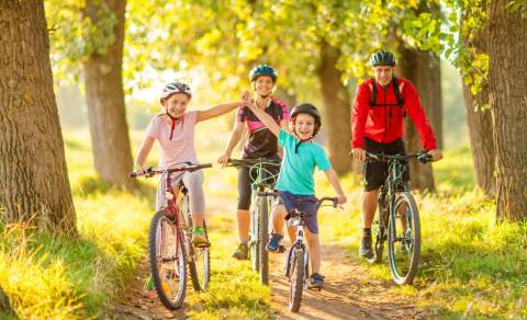 family of four two children at the front cycling on a sunny day