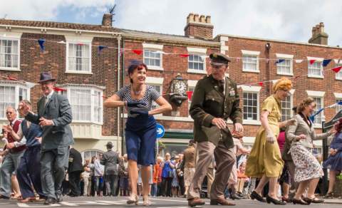 A group of dancers dressed in 1940s costume performing on stage for the 1940s and 50s summer festival in Bridlington, East Yorkshire